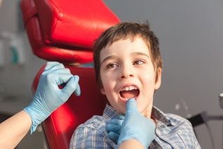Un niño es examinado por un dentista.
