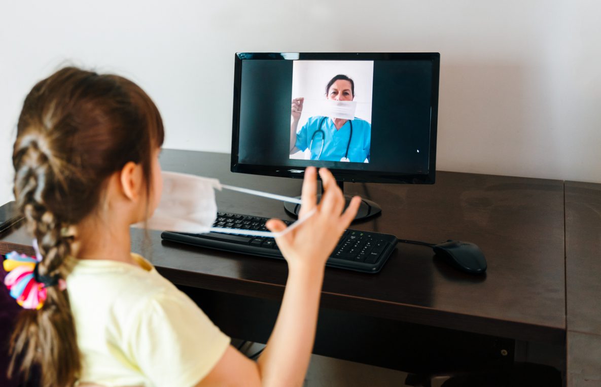 Elementary age girl learns to wear a mask with video conferencing from school nurse