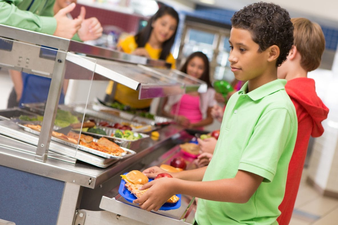 Student getting lunch in school cafeteria line.