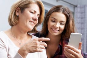 mother and daughter looking at resources on a smartphone
