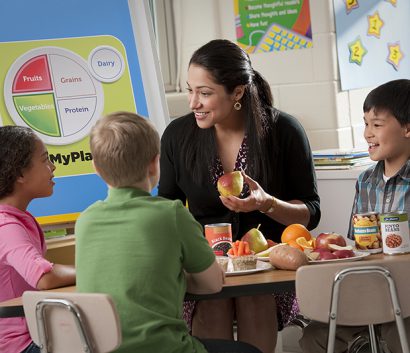 teacher eating healthy lunch with kids