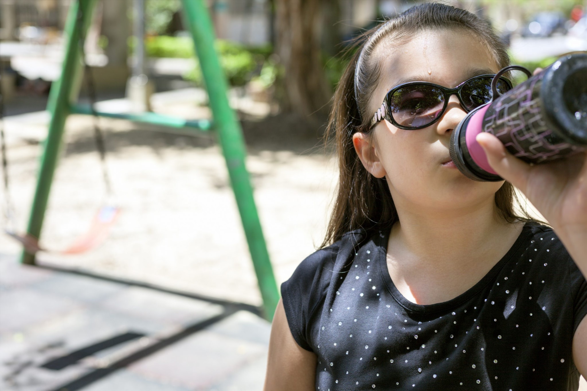 Girl with water bottle on playground