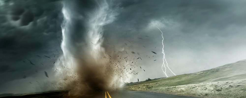Image of a large tornado during touch down on an empty long road.