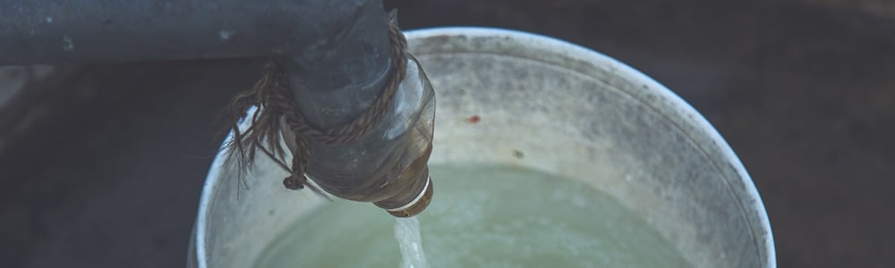 bucket being filled with water at borehole