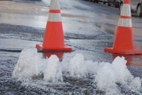 Orange safety cones marking a flooding street