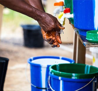 Image of hands being washed from an outside water despenser