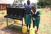 Image of Two members of the safe water club at Sino SDA Primary School in Nyanza Province in rural Kenya treating the school drinking water with WaterGuard.