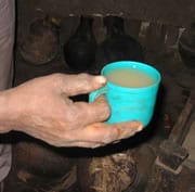 Photo showing a cup containing muddy, cloudy water that a woman in Ethiopia has prepared as she would for her child