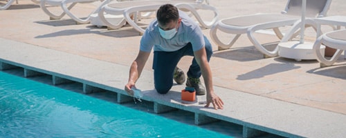 Pool testing kit being used in a swimming pool