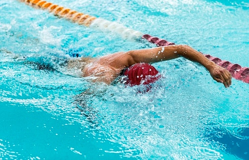 Young athletic man swimming in olympic pool