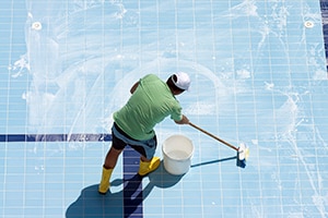 man scrubbing a public pool