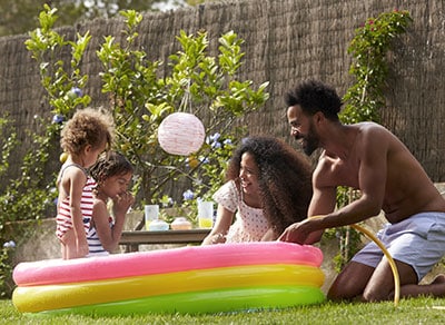 Familia jugando en una piscina para niños