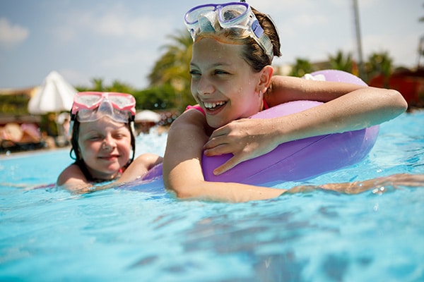 Imagen de dos niñas nadando en la piscina