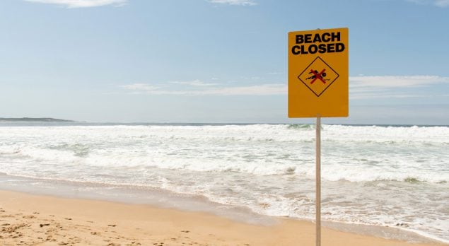Cartel de playa cerrada en una playa