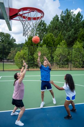 four teenagers playing basketball