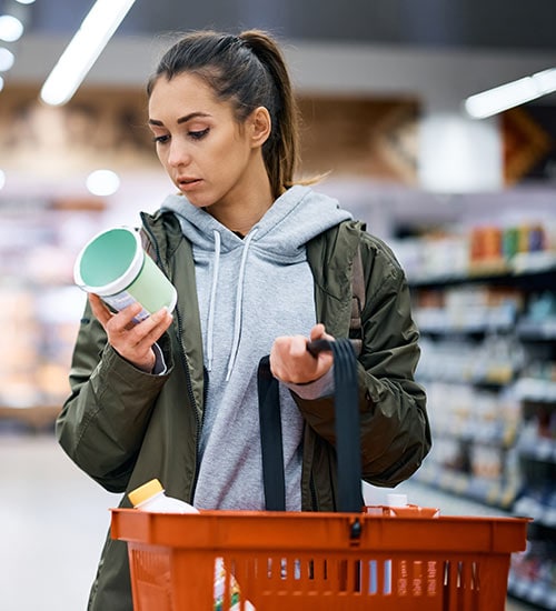 A woman reading the label of a food container
