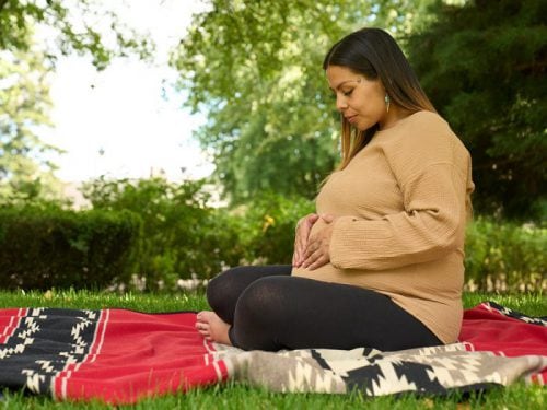 Pregnant woman on red blanket