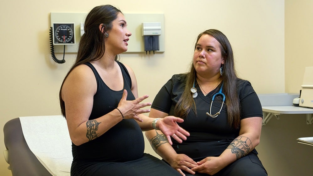 Pregnant woman talking to health care professional.