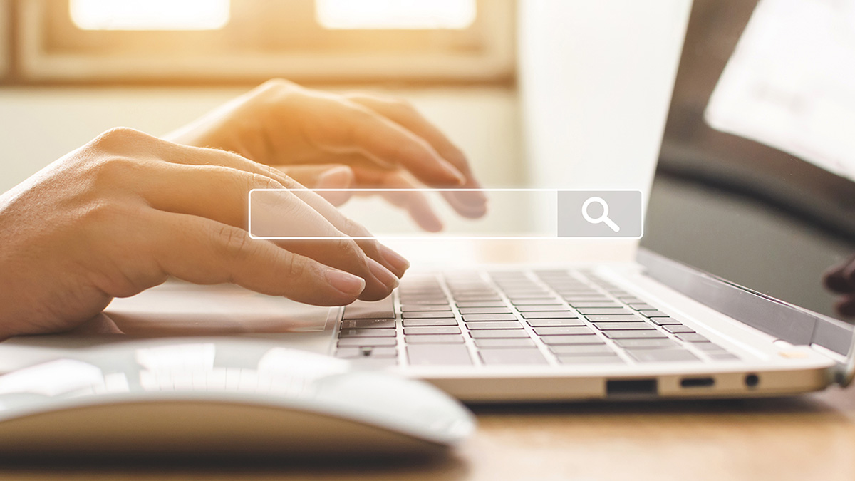 Hand of male typing text on laptop keyboard