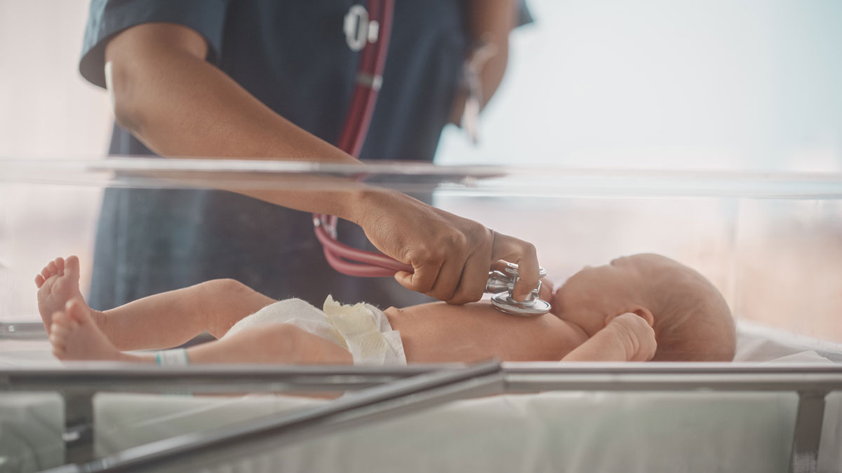 A healthcare professional listening to a baby's heart with stethoscope