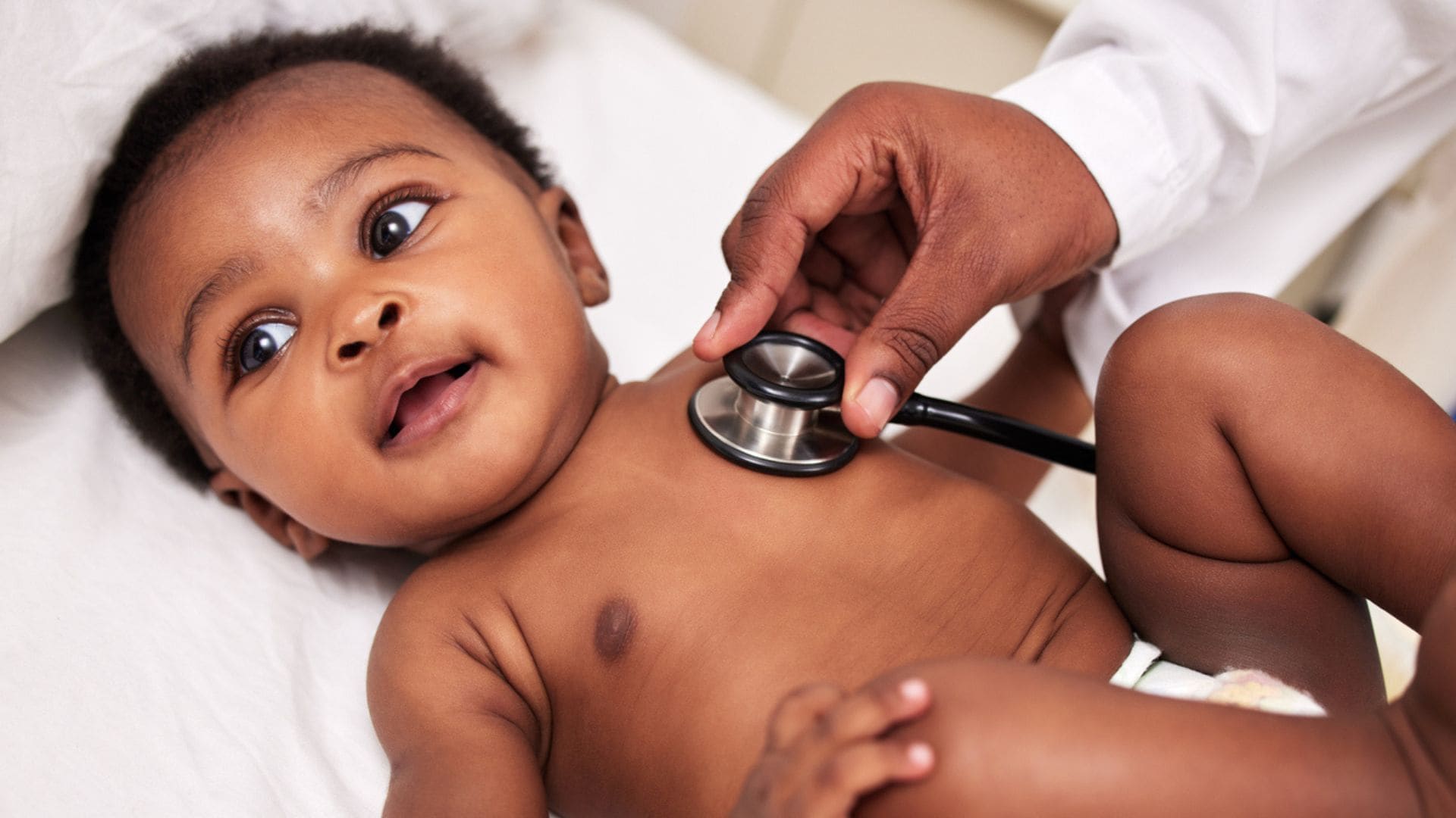 A baby having his heart listened to with a stethoscope