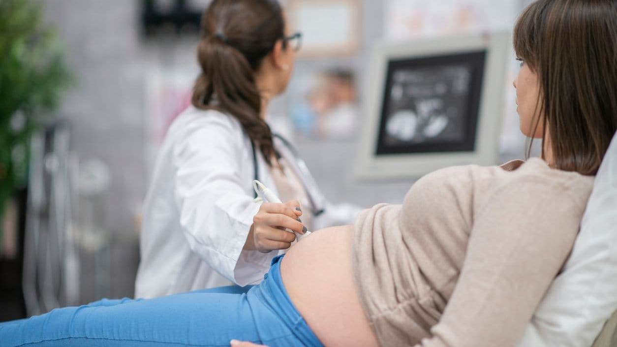 A pregnant woman receives an ultrasound.