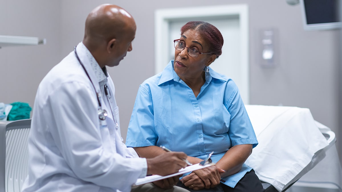 A physician talking to a patient during a medical exam.
