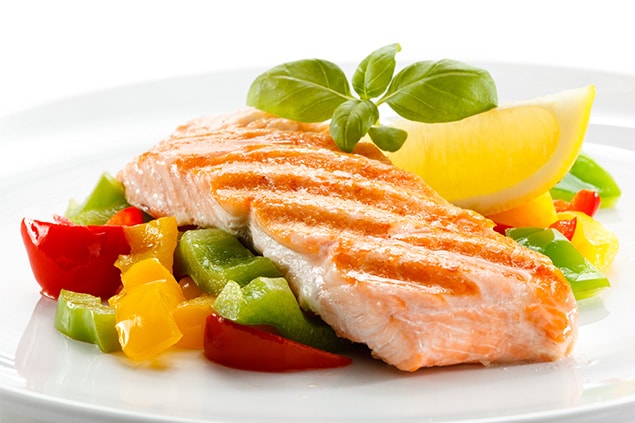 A healthy plate with fish and vegetables on it.
