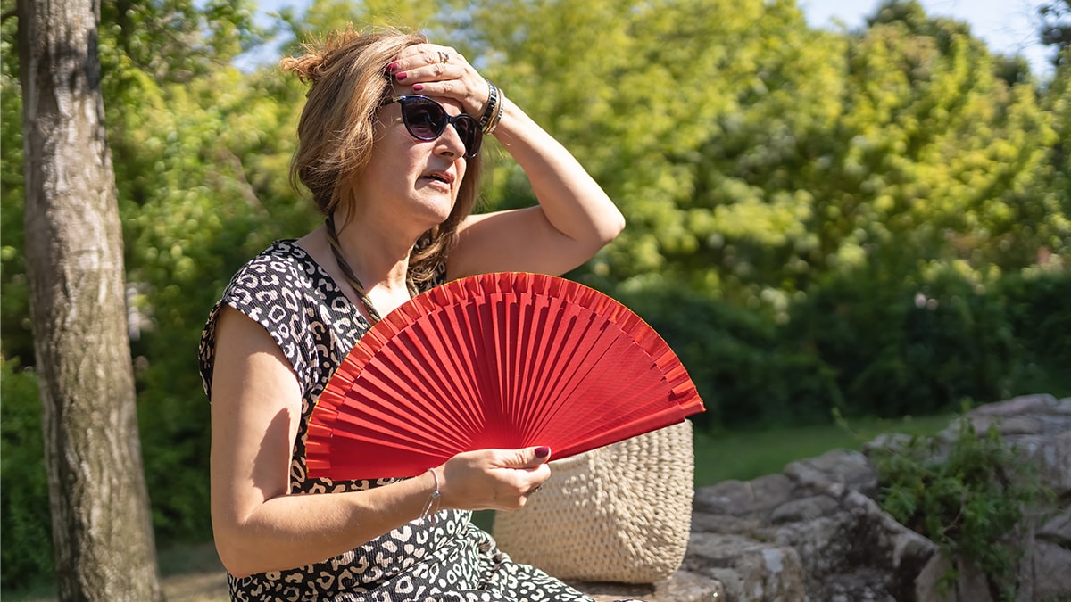 Mature woman experiencing heatwave outdoors.