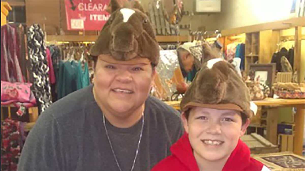 Mother and son smiling wearing hats in the shape of a horse