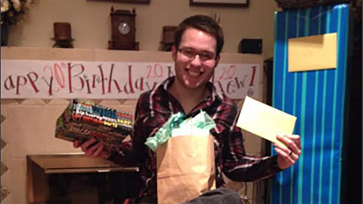 Young man in a wheel chair smiling as he opens gifts