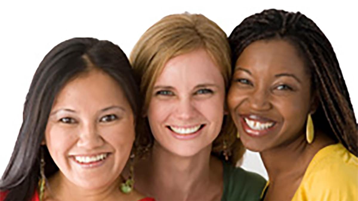 Three women of different races smiling