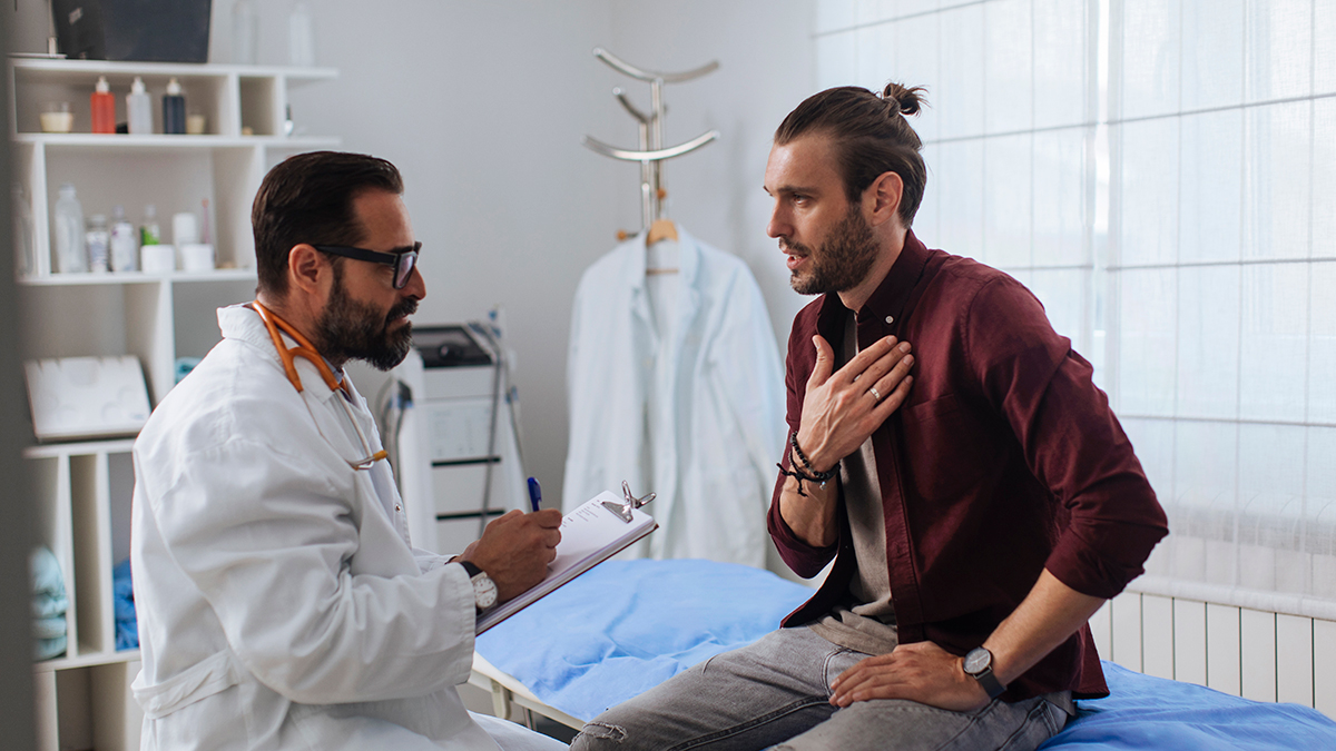 A patient explaining his symptoms to a doctor while the doctor takes notes