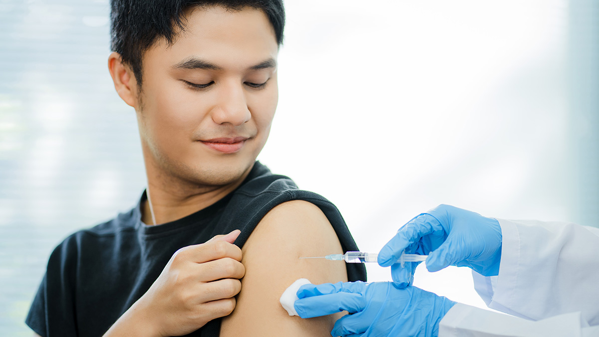 A doctor administering a vaccine in a man's shoulder