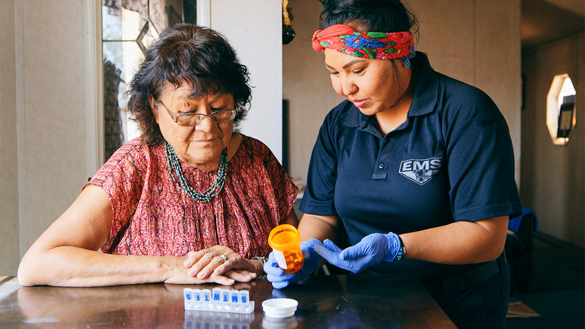 A medical professional helping a woman with sorting her medication
