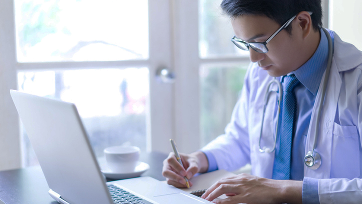 Doctor reviewing hepatitis c healthcare resources on their laptop