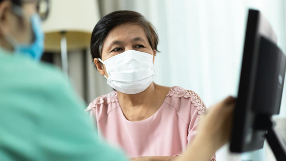 A masked tuberculosis patient receives a doctor consultation.