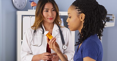 Photo of a patient examining medication with doctor