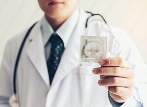photo of a doctor handing out a condom
