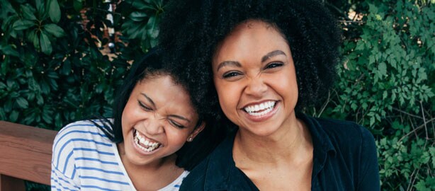 Two African-American women leaning on each other smiling. National HIV Testing Day. June 227. Encourage people to get tested for HIV, know their status, and get linked to care and treatment.