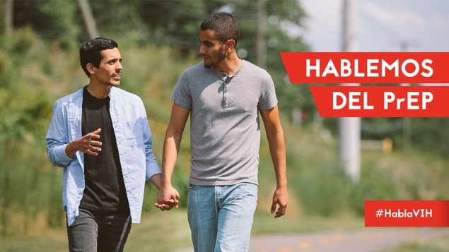 Dos hombres caminando afuera agarrados de la mano y sonriendo. El texto dice: Hablemos del PrEP. #HablaVIH