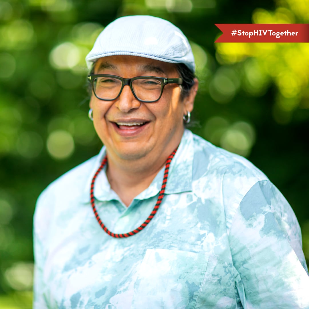 A man smiling outside. Text says #StopHIVTogether.