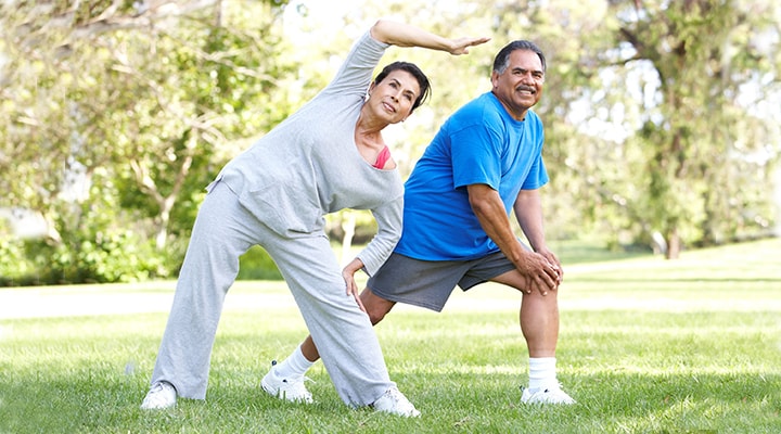 Older couple stretching in a park