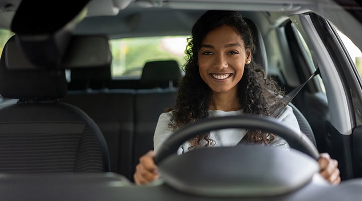 Photo of female looking very happy driving a car