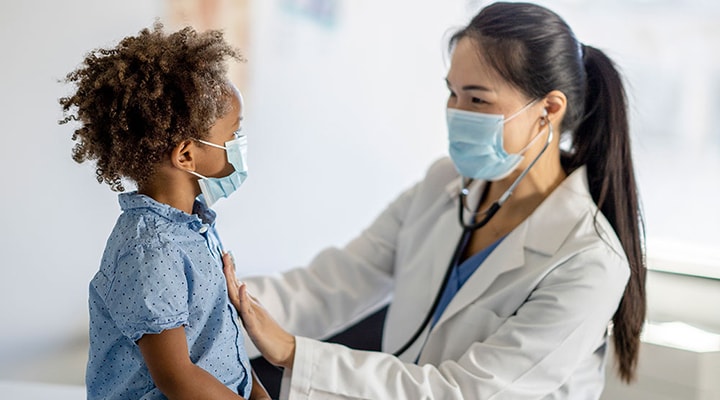 A doctor assisting a young child