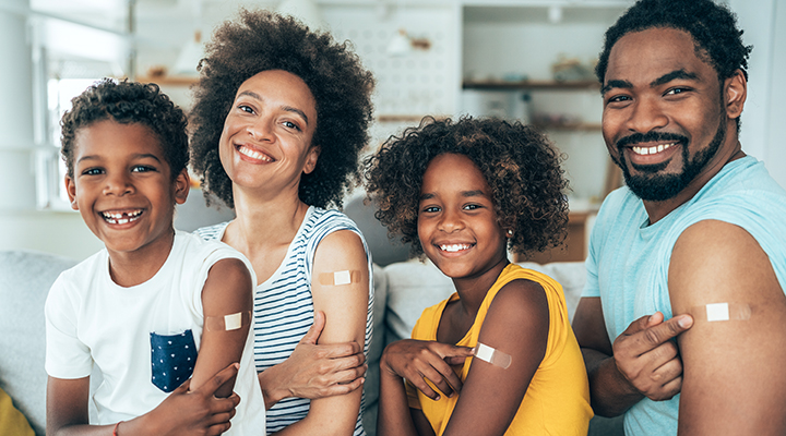 Respiratory Illness Smiling family with adhesive bandages on their arms.