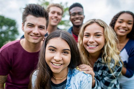 A group of six smiling teenagers