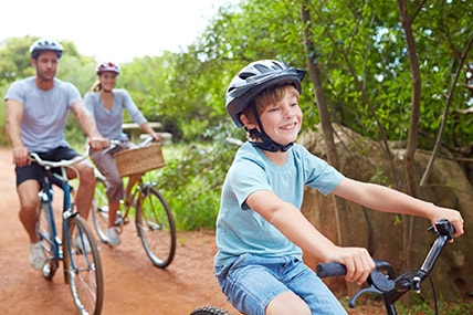 Young couple riding bikes with son