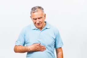 Mature man holding his stomach in pain.