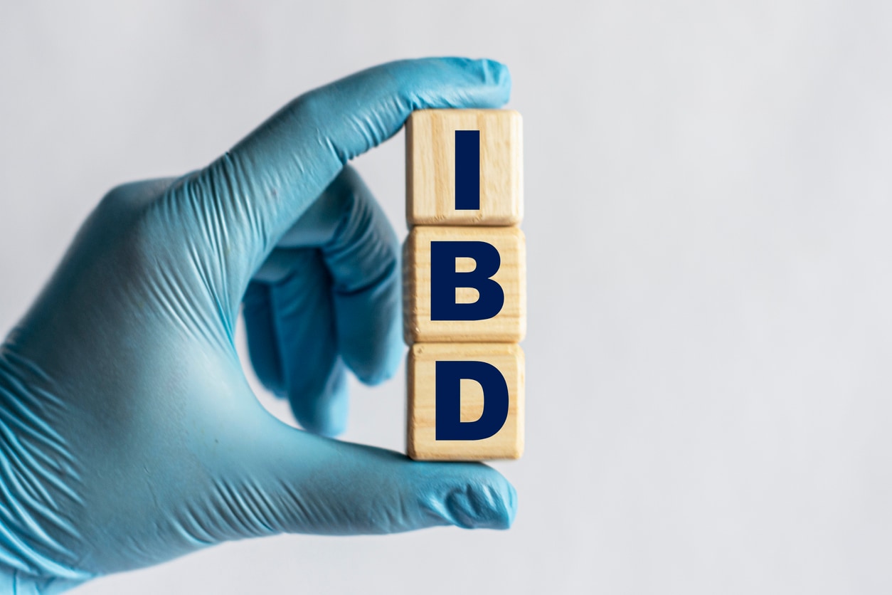 IBD is an acronym on cubes held by a hand in a blue glove
